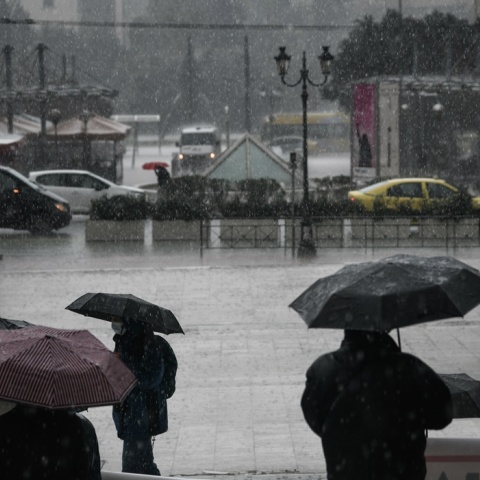 Βροχή στο κέντρο της Αθήνας και πολίτες με ομπρέλες