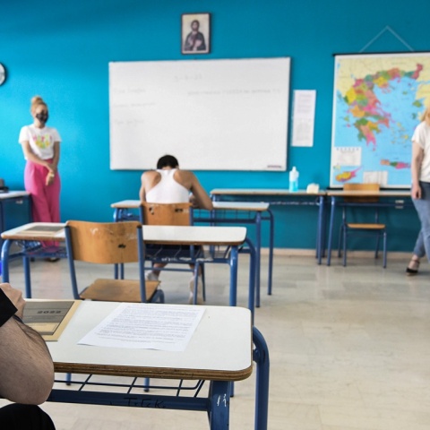 Εξεταστικό κέντρο και μαθητές πάνω από τα γραπτά τους κατά τη διάρκεια των Πανελλήνιων Εξετάσεων 2023