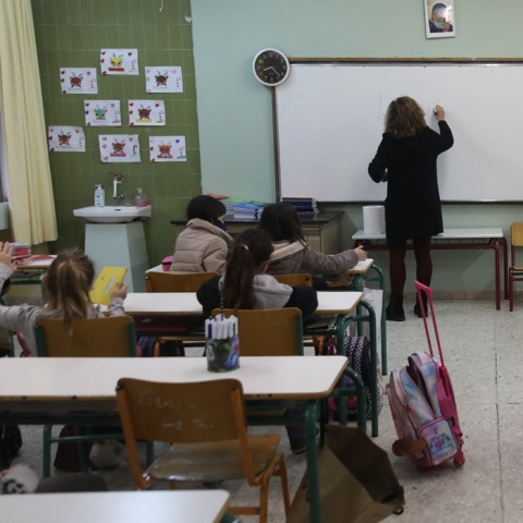 Δασκάλα μπροστά από τον πίνακα διδάσκει σε μαθητές δημοτικού