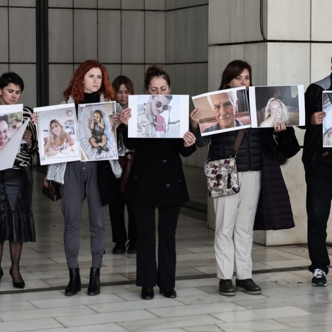 Συγγενείς θυμάτων της πύρινης τραγωδίας στο Μάτι κρατούν φωτογραφίες των νεκρών έξω από το δικαστήριο