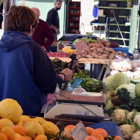Πολίτες ψωνίζουν από τους πάγκους της λαϊκής αγοράς