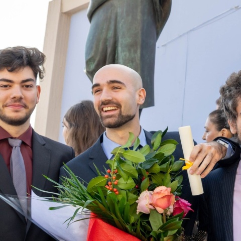 Ο Σεβαστός Κουμτζής κρατά στο χέρι του το πτυχίο του, έχοντας στο πλευρό του τον αδελφό του Αργύρη