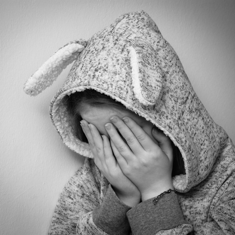 Ανήλικη κρύβει με τα χέρια το πρόσωπό της, ενώ με κουκούλα κρύβει το κεφάλι της