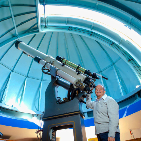 Holomon Station - Τηλεσκόπιο στον σταθμό και επιστήμονας που ποζάρει με χαμόγελο