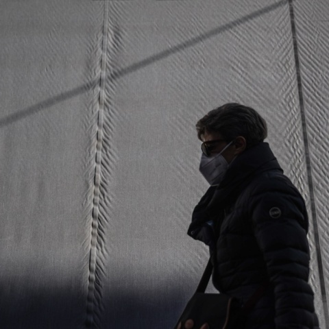 Γυναίκα περπατά φορώντας τη μάσκα προστασίας κατά του κορωνοϊού