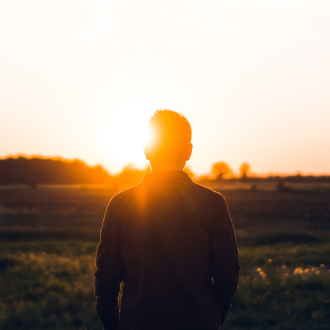 άντρας που στέκεται μπροστά στο ηλιοβασίλεμα
