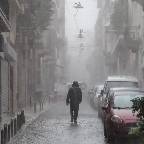 Άτομο κάτω από ισχυρή καταιγίδα σε δρόμο της Αθήνας - Υπό καταρρακτώδη βροχή στον δρόμο