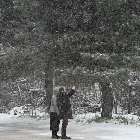 Πολίτες φωτογραφίζονται κατά τη διάρκεια χιονόπτωσης
