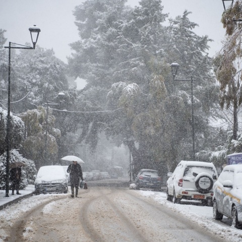 Γυναίκα με ομπρέλα στα χιόνια της Αττικής