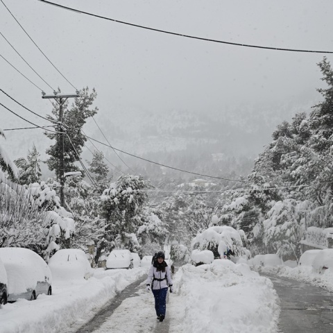 Χιόνια από την κακοκαιρία «Μπάρμπαρα» - Γυναίκα περπατά σε χιονισμένο δρόμο