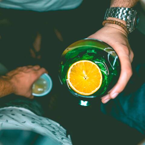 Έφηβοι κρατούν ποτήρια με ποτά κατά τη διάρκεια νυχτερινής τους εξόδου σε μπαρ