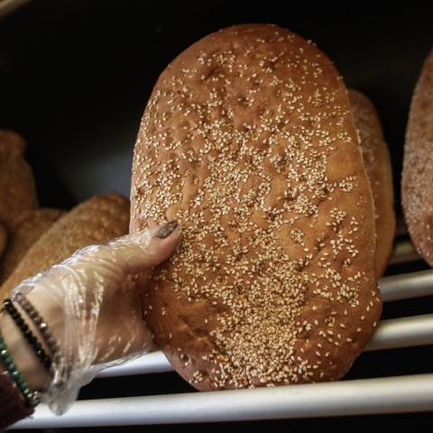 Χέρι αρτοπώλη κρατά λαγάνα