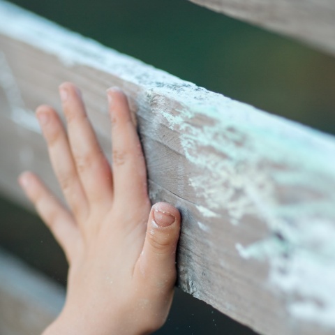 Χεράκι παιδιού σε ξύλινο φράκτη