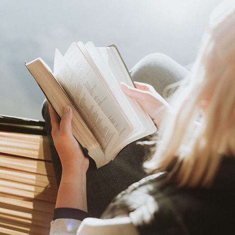 Μια γυναίκα κρατάει ένα βιβλίο. 