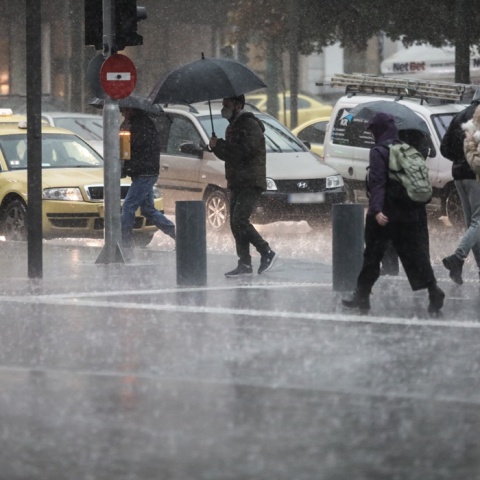 Πολίτες με ομπρέλες κατά τη διάρκεια ισχυρής καταιγίδας στο κέντρο της Αθήνας