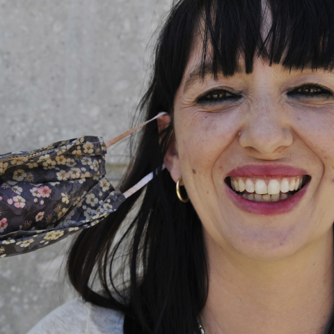 Γυναίκα έχει βγάλει τη μάσκα προστασίας της για τον κορωνοϊό και χαμογελά 