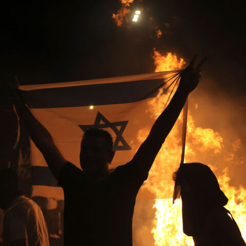 Άνδρας με σημαία του Ισραήλ διαμαρτύρεται για την αναθεώρηση του δικαστικού συστήματος