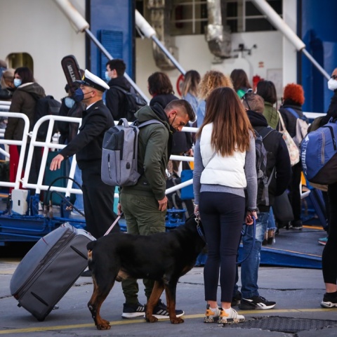 Πολίτες με βαλίτσες και κατοικίδιο στο λιμάνι του Πειραιά αναμένουν την επιβίβασή τους στο πλοίο