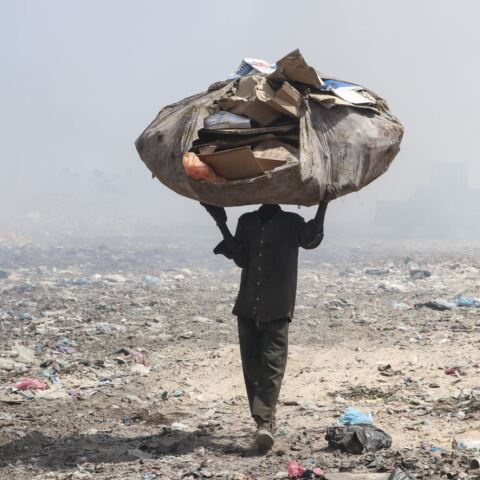 Ένας συλλέκτης σκουπιδιών μεταφέρει ανακυκλωμένα υλικά από μια χωματερή για να βγάλει τα προς το ζην στην οικογένειά του