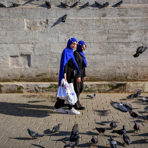 Γυναίκες περπατούν δίπλα από περιστέρια σε δρόμο στην Τουρκία