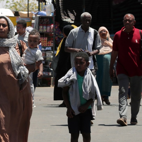 Γυναίκα με τα παιδιά της φεύγει από το Σουδάν μετά το ξέσπασμα των συρράξεων