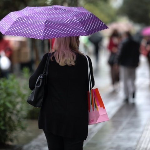 Γυναίκα με ομπρέλα προστατεύεται από βροχόπτωση