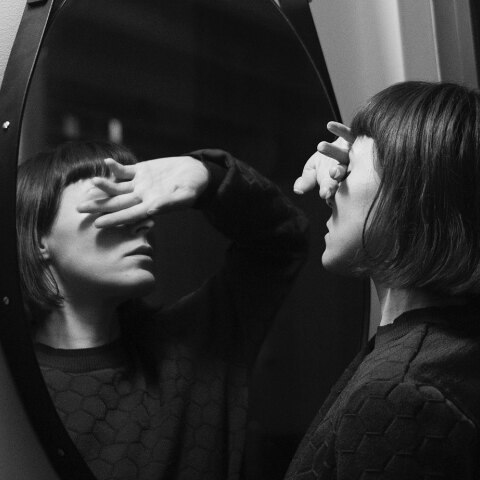 Γυναίκα καλύπτει τα μάτια της μπροστά σε καθρέφτη