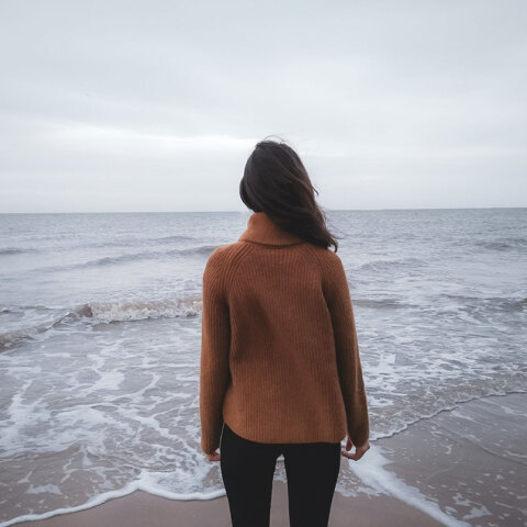 Κοπέλα με γυρισμένη πλάτη κοιτάζει τη θάλασσα