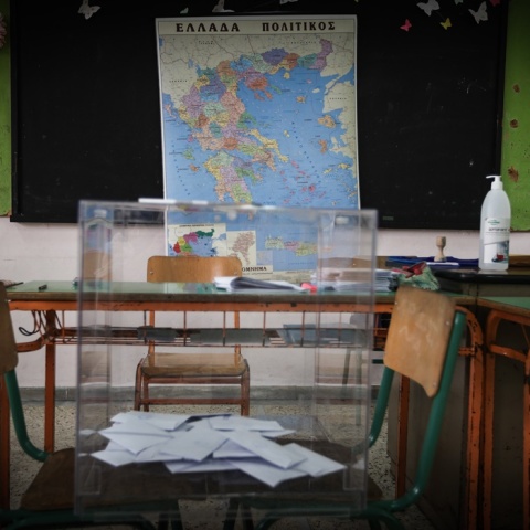 Κάλπη στερεωμένη σε δύο καρέκλες μπροστά από τον χάρτη της Ελλάδας