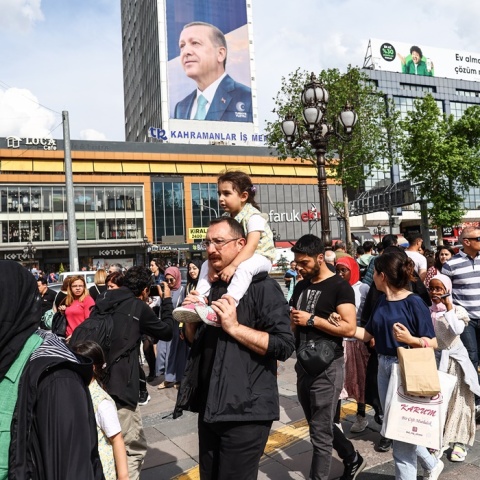 Πολίτες περπατούν μπροστά από αφίσα του Ρετζέπ Ταγίπ Ερντογάν - Σήμερα οι δεύτερες εκλογές στην Τουρκία