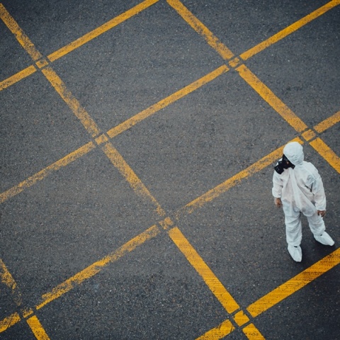 Άτομο με στολή προστασίας από πανδημία σε άδειο δρόμο