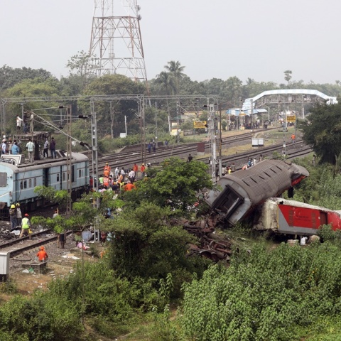 Χαλάσματα και εργάτες για να τα απομακρύνουν από το σημείο όπου καταγράφηκε το σιδηροδρομικό δυστύχημα στην Ινδία