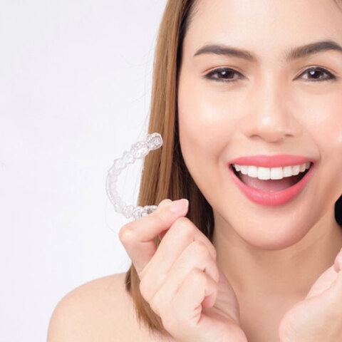 Κοπέλα κρατάει διάφανα μασελάκια