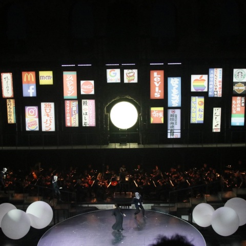 Η παρουσίαση της παράστασης «Μαντάμα Μπατερφλάι» από τον Ολιβιέ Πι και η επιλογή προβολής λογοτύπων πολυεθνικών εταιρειών στον τοίχο του Ηρωδείου.