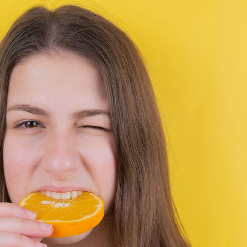 Κοπέλα δαγκώνει πορτοκάλι