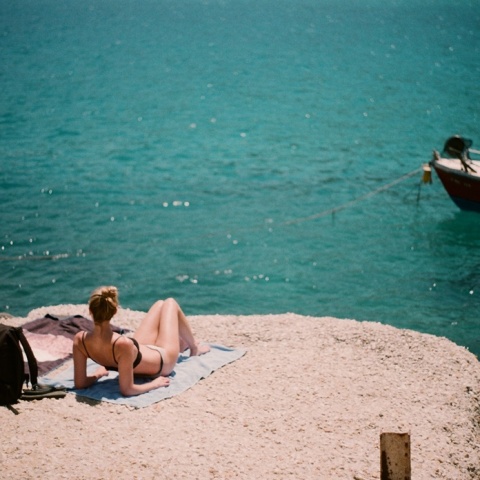 Γυναίκα απολαμβάνει την ηλιοθεραπεία σε παραλία 