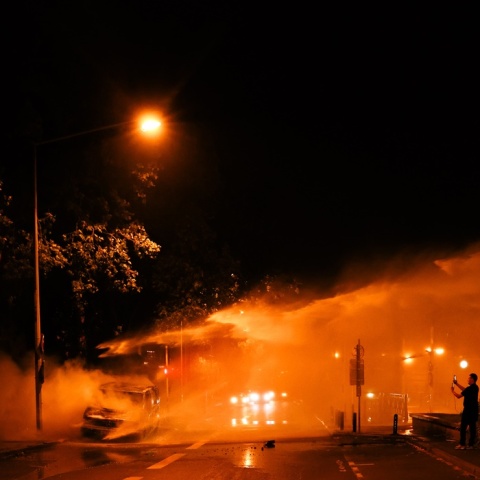 Φλεγόμενο λεωφορείο και πυροσβέστες που επιχειρούν για την ολοκληρωτική κατάσβεσή του