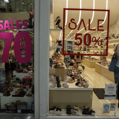 Γυναίκα σε βιτρίνα καταστήματος παπουτσιών με εκπτώσεις