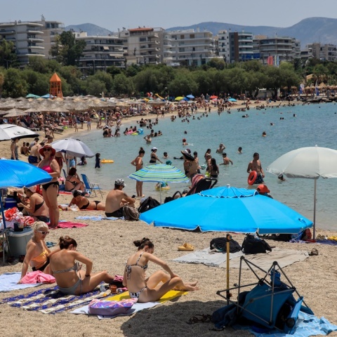 Λουόμενοι σε παραλία απολαμβάνουν ήλιο και θάλασσα