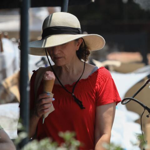 Γυναίκα απολαμβάνει ένα χωνάκι παγωτό στην προσπάθειά της να δροσιστεί