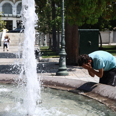 Άνδρας δροσίζεται στο συντριβάνι του ΣυντάγματοςΆνδρας δροσίζεται στο συντριβάνι του Συντάγματος