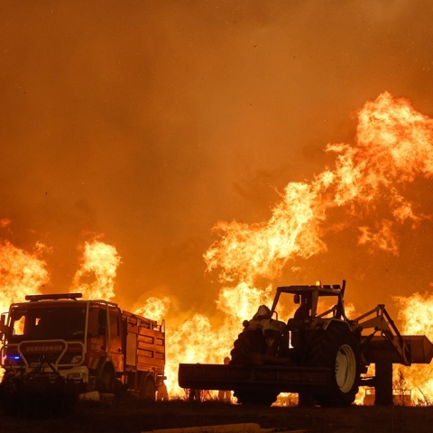 Φωτιά στην Πορτογαλία και οι σκιές ατόμου και οχημάτων με φόντο τις φλόγες