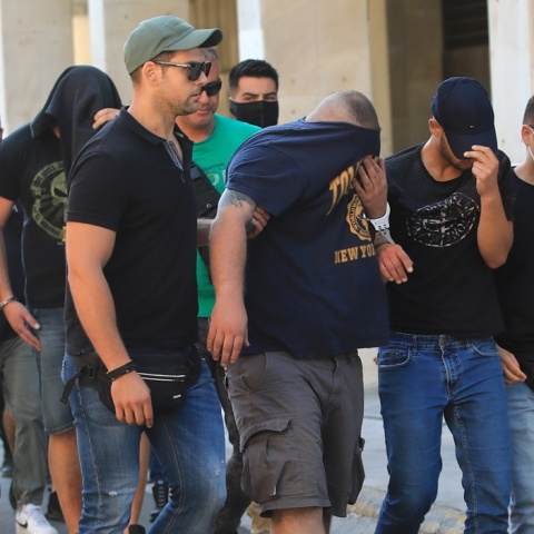 Οι συλληφθέντες κρύβουν το πρόσωπό τους προσερχόμενοι στο γραφείο του εισαγγελέα για τη δολοφονία του Μιχάλη Κατσουρή