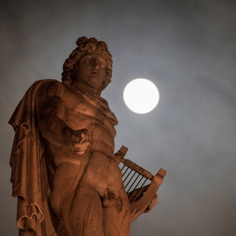 Μπλε φεγγάρι φωτίζει τον ουρανό πίσω από άγαλμα