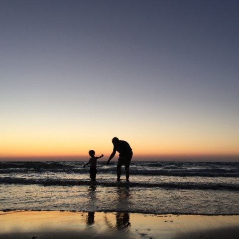 Παιδί παίζει με τον μπαμπά του στην ακροθαλασσιά