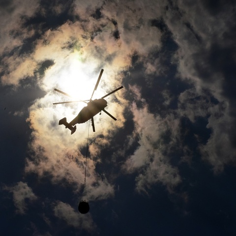 Πυροσβεστικό ελικόπτερο σε λήψη από κάτω με φόντο τα σύννεφα