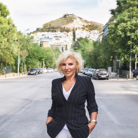 Η Πόπη Διαμαντάκου φωτογραφισμένη στη μέση του δρόμου με φόντο τον λόφο του Λυκαβηττού