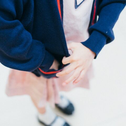 Παιδάκι που φορά στολή στο σχολείο - Διακρίνονται τα ρούχα και τα χεράκια του