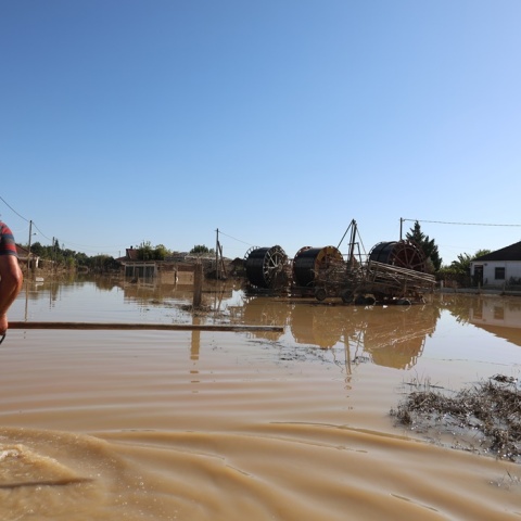 Πλημμύρες στη Θεσσαλία και άνθρωποι που περπατούν στα νερά ή είναι μέσα σε βάρκα