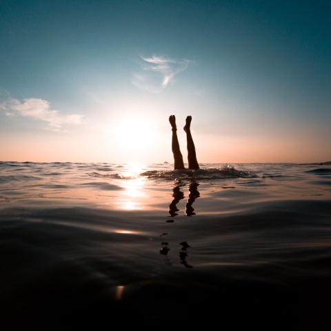 Άτομο βουτά στη θάλασσα και διακρίνονται μόνο τα πόδια του